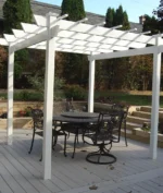 Kingston white vinyl pergola on a composite deck, shading a black metal dining set